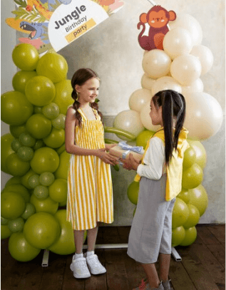 People celebrating a birthday with a cake and balloons